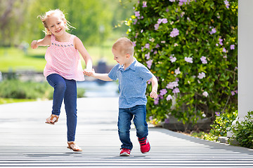 Image showing Young Sister and Brother Holding Hands And Running At The Park