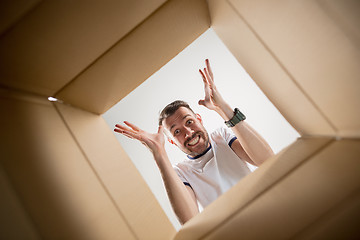 Image showing Man unpacking and opening carton box and looking inside