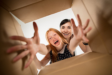 Image showing mom and daughter unpacking and opening carton box and looking inside