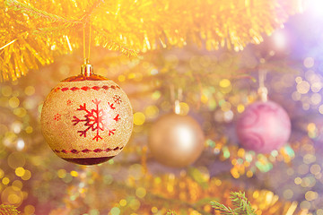 Image showing Christmas-tree decoration bauble on decorated Christmas tree bac