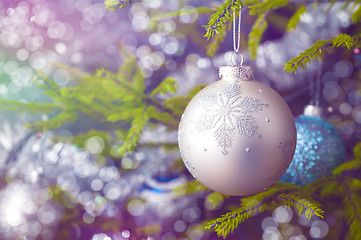 Image showing Christmas-tree decoration bauble on decorated Christmas tree bac