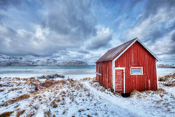 Image showing Red rorbu house shed on beach of fjord, Norway