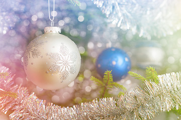 Image showing Christmas-tree decoration bauble on decorated Christmas tree bac