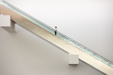 Image showing man rolling downwards on an escalator