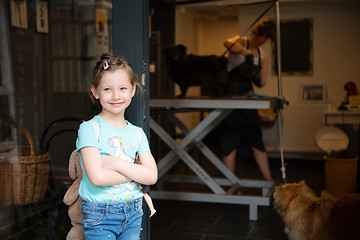 Image showing little cute girl standing in front of beauty salon for animals