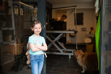 Image showing little cute girl standing in front of beauty salon for animals