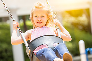 Image showing Pretty Young Girl Having Fun On The Swings At The Playground