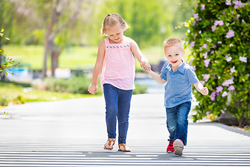 Image showing Young Sister and Brother Holding Hands And Walking At The Park