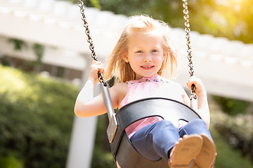 Image showing Pretty Young Girl Having Fun On The Swings At The Playground