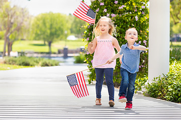 Image showing Young Sister and Brother Waving American Flags At The Park