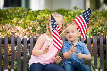 Image showing Young Sister and Brother Waving American Flags On The Bench At T