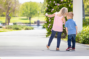 Image showing Young Sister and Brother Holding Hands And Walking At The Park
