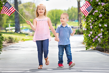 Image showing Young Sister and Brother Waving American Flags At The Park