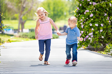 Image showing Young Sister and Brother Holding Hands And Running At The Park