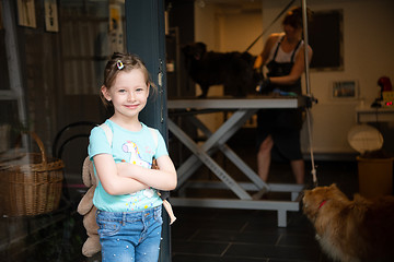 Image showing little cute girl standing in front of beauty salon for animals