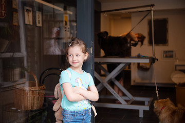 Image showing little cute girl standing in front of beauty salon for animals