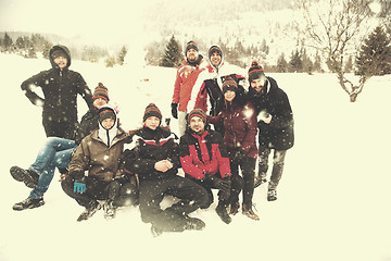 Image showing group portait of young people posing with snowman