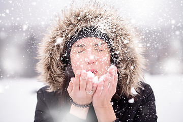 Image showing young woman blowing snow on snowy day