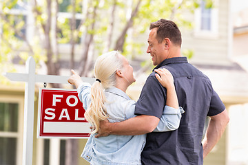 Image showing Caucasian Couple Facing and Pointing to Front of For Sale Real E