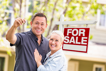 Image showing Caucasian Couple in Front of For Sale Real Estate Sign and House