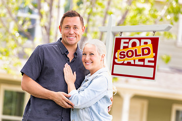 Image showing Caucasian Couple in Front of Sold Real Estate Sign and House