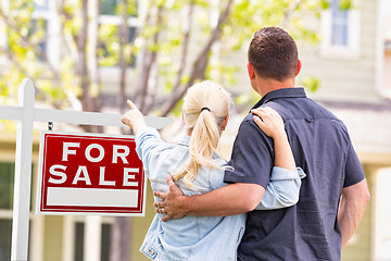 Image showing Caucasian Couple Facing and Pointing to Front of For Sale Real E