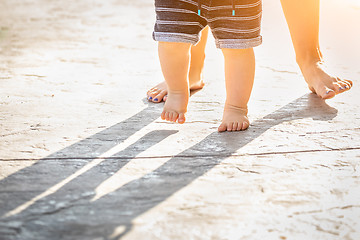 Image showing Mother and Baby Feet Taking Steps Outdoors