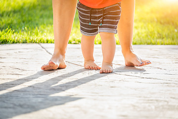 Image showing Mother and Baby Feet Taking Steps Outdoors