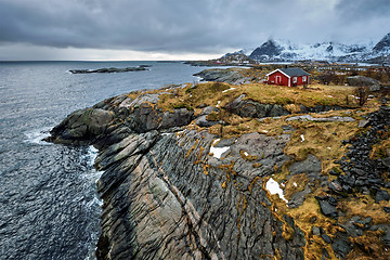 Image showing Clif with traditional red rorbu house on Lofoten Islands, Norway