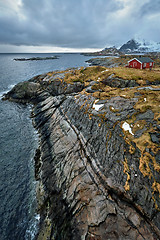 Image showing Clif with traditional red rorbu house on Lofoten Islands, Norway