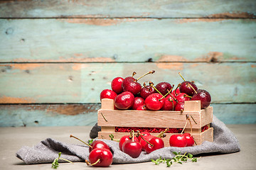 Image showing Red ripe cherries in small wooden box