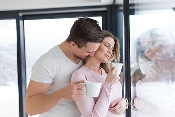 Image showing young couple enjoying morning coffee by the window