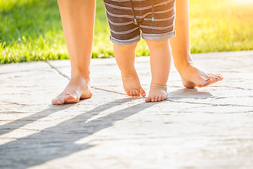 Image showing Mother and Baby Feet Taking Steps Outdoors