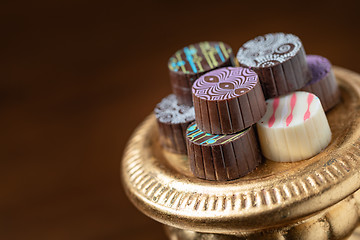 Image showing Artisan Fine Chocolate Candy On Gold Pillar Serving Dish