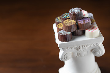 Image showing Stack of Fine Artisan Chocolates Stacked On White Pillar Column