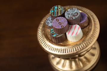 Image showing Artisan Fine Chocolate Candy On Gold Pillar Serving Dish