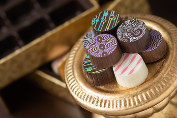 Image showing Artisan Fine Chocolate Candy On Gold Pillar Serving Dish