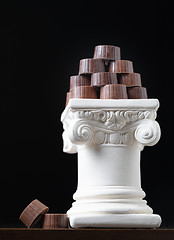 Image showing Stack of Fine Artisan Chocolates Stacked On White Pillar Column