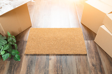 Image showing Blank Welcome Mat, Moving Boxes and Plant on Hard Wood Floors