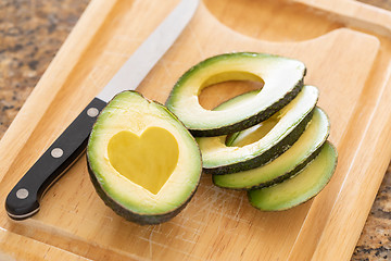 Image showing Fresh Cut Avocado With Heart Shaped Pit Area On Wooden Cutting B