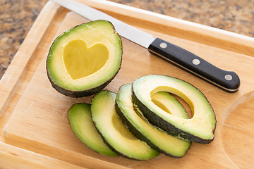 Image showing Fresh Cut Avocado With Heart Shaped Pit Area On Wooden Cutting B