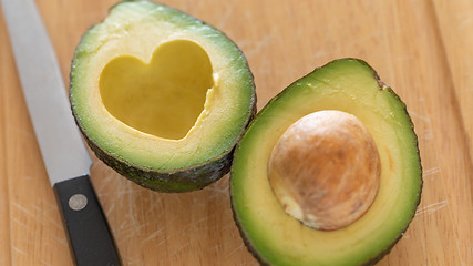 Image showing Fresh Cut Avocado With Heart Shaped Pit Area On Wooden Cutting B