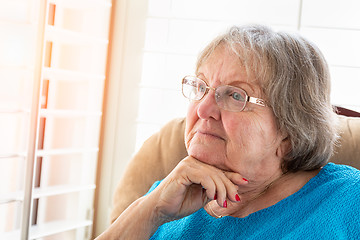 Image showing Contemplative Senior Woman Gazing Out of Her Window