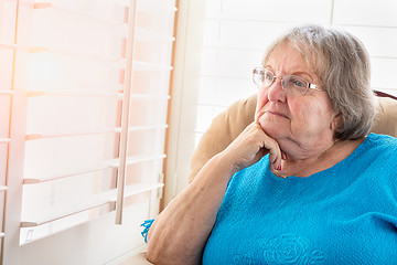 Image showing Contemplative Senior Woman Gazing Out of Her Window