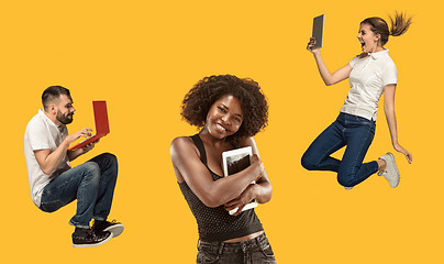 Image showing The happy young jumping women and men with laptops