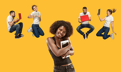 Image showing The happy young jumping women and men with laptops
