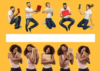 Image showing The happy young jumping women and men with laptops