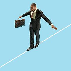 Image showing Business man on tightrope concentrate to walking isolated on blue background