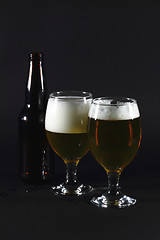 Image showing Two glasses full with beer and  beer bottle.  