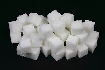 Image showing Spilled Cubes Sugar on pile over black. 